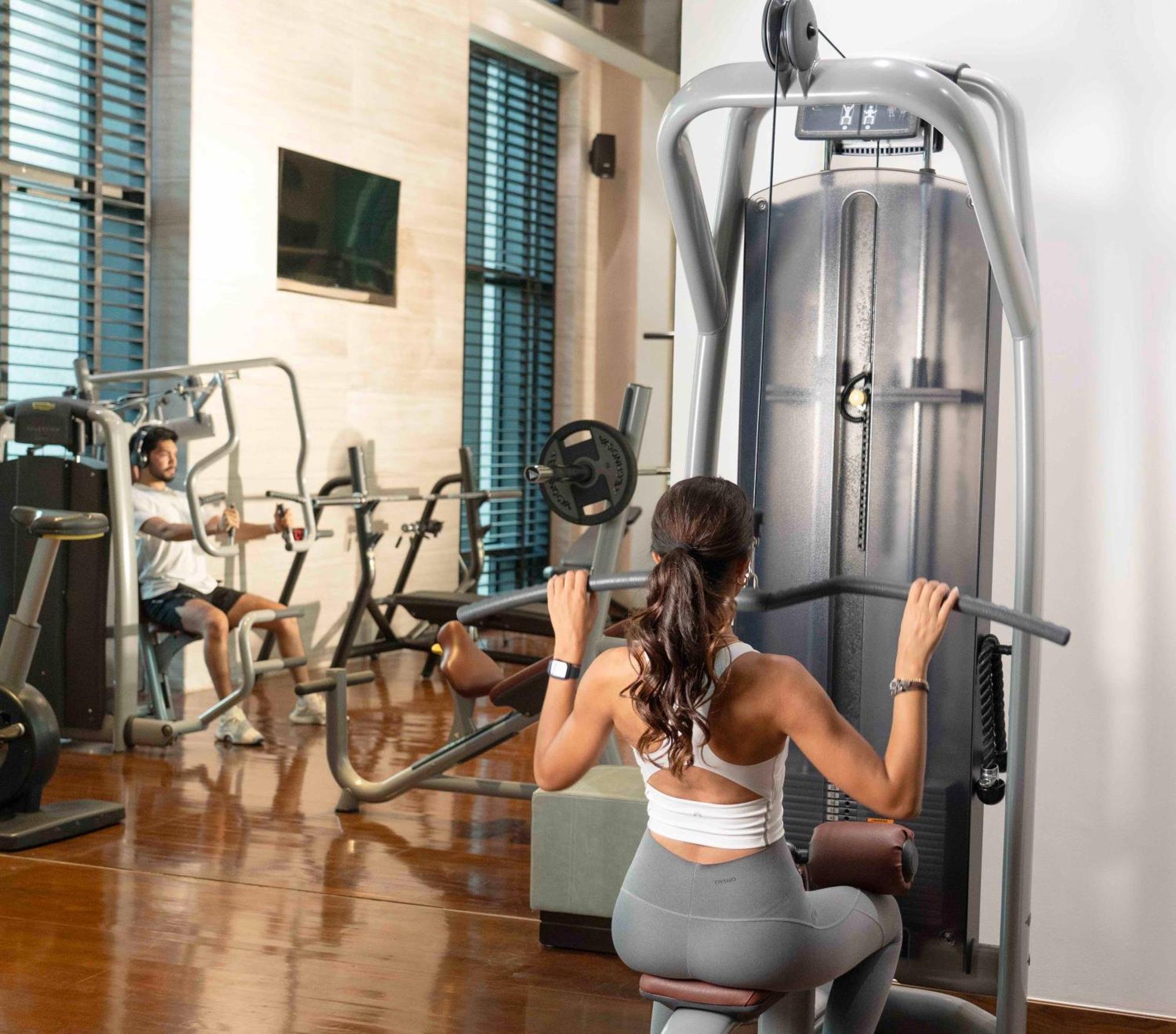 Fairmont リヤード エクステリア 写真 A woman using a lat pulldown machine